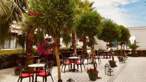 a patio with tables and chairs and palm trees at Sura Hagia Sophia Hotel in Istanbul