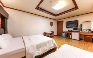 a hotel room with two beds and a flat screen tv at Prince Hotel in Gwangju