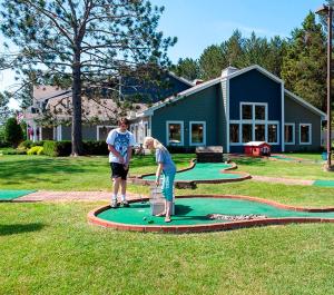 a man and a woman playing golf on a putting green at Country Inn Two Harbors in Two Harbors