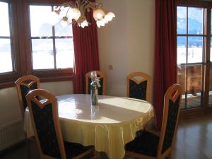 una mesa de comedor con sillas y un jarrón. en Appartement Mayr en Kirchdorf in Tirol