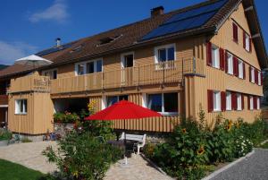 uma casa com painéis solares na lateral em Ferienwohnung Sonnenhof em Andelsbuch