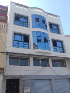 a building with blue windows on the side of it at Al-marsa2 in Al Hoceïma
