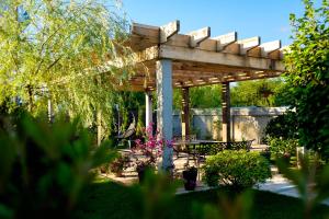 a wooden pergola with a picnic table in a garden at RestCoast Villa in Shekvetili