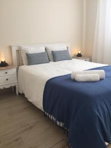 ein Schlafzimmer mit einem großen Bett mit einer blauen Decke in der Unterkunft Casas do Navalhão in São Roque do Pico