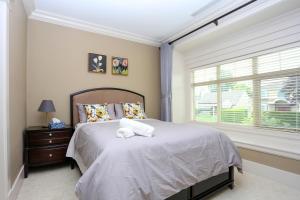 Un dormitorio con una cama grande y una ventana en Grand House in Westside Vancouver en Vancouver