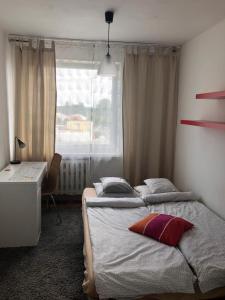 グダニスクにあるApartament Przymorzeのベッドルーム1室(ベッド2台、デスク、窓付)
