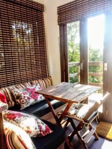 sala de estar con mesa de madera y sofá en Praia do Rosa para casais, en Imbituba