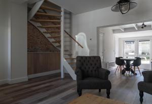 sala de estar con escalera, sillas y mesa en Het Dokhuis, en Middelburg