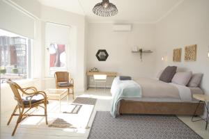 a bedroom with a bed and a desk and a chair at MOY Guesthouse & Backpackers in Cape Town
