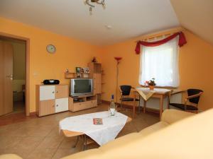 a living room with a table and a television at Schölzke‘s Ferienhaus in Ralswiek