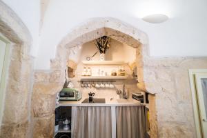 a kitchen with a stone archway and a sink at Antiqua Nova in Ceglie Messapica