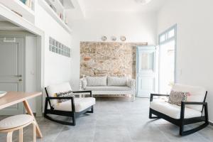 ein Wohnzimmer mit 2 Stühlen und einem Sofa in der Unterkunft Achinos guest house, Skopelos in Skopelos