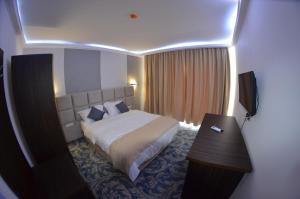 a hotel room with a bed and a desk in it at Hotel AquaMarine in Costinesti