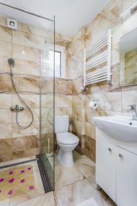 ein Bad mit einer Dusche, einem WC und einem Waschbecken in der Unterkunft Dom Gościnny Marcela in Rewal