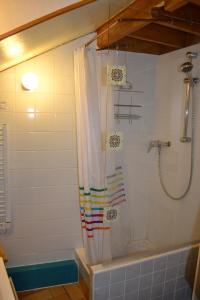 a shower with a shower curtain in a bathroom at Appartement Résidence Napoléon in Cauterets