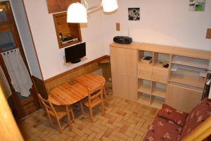 a small kitchen with a wooden table and a desk at Appartement Résidence Napoléon in Cauterets