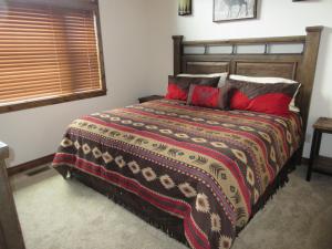 a bedroom with a large bed with red pillows at Townhomes on the Green in Afton