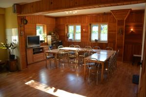 a dining room with tables and chairs and a television at Zawojka in Zawoja