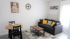 a living room with a couch and a table at Appartement Le Mans Libération in Le Mans +10 photos