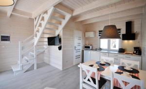 a kitchen and dining room with a table and chairs at Białe Domki Lux in Grzybowo