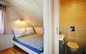 a small bedroom with a bed in a tiny house at Białe Domki Lux in Grzybowo +36 photos