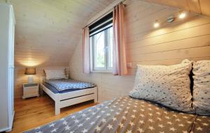niewielka sypialnia z łóżkiem i oknem w obiekcie Białe Domki Lux w Grzybowie