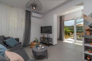 a living room with a gray couch and a large window at Apartments Flora Trogir in Trogir
