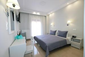 a bedroom with a bed and a tv in it at Limnia Gi in Myrina