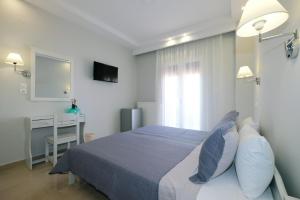 a bedroom with a bed and a desk and a window at Limnia Gi in Myrina