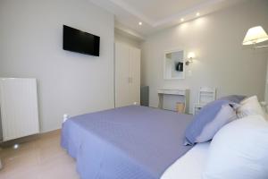 a bedroom with a bed and a tv on the wall at Limnia Gi in Myrina