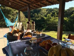 a picnic table with bread and bottles of wine and bananas at Pousada Som das Águas Bueno Brandão in Bueno Brandão +45 photos