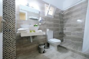 a bathroom with a toilet and a sink and a shower at Limnia Gi in Myrina