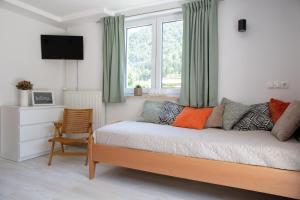 um quarto com uma cama, uma janela e uma cadeira em Apartments Korošec em Bled