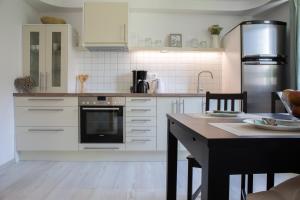 uma cozinha com electrodomésticos brancos e uma mesa com cadeiras em Apartments Korošec em Bled