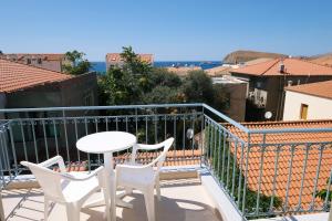 a balcony with a table and chairs and a view at Limnia Gi in Myrina