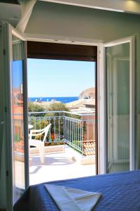 a bedroom with a view of a balcony with a bed at Limnia Gi in Myrina