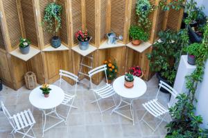 a patio with tables and chairs and potted plants at One Three One - In the Heart of Athens in Athens