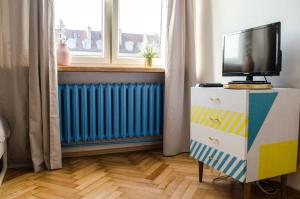 Habitación con TV, cómoda y radiador. en New Life Apartment next to Metro Station, en Varsovia