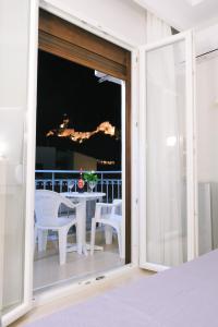an open door to a balcony with a table and chairs at Limnia Gi in Myrina