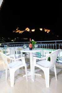 a white table and chairs with a bottle of wine at Limnia Gi in Myrina