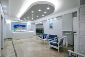 a waiting room with two blue chairs and a table at Limnia Gi in Myrina