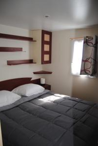 מיטה או מיטות בחדר ב-MOBILHOME 3 CHAMBRES
