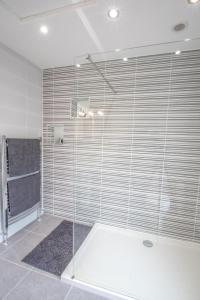 a shower with glass doors in a bathroom at Altahammond House in Carrickfergus