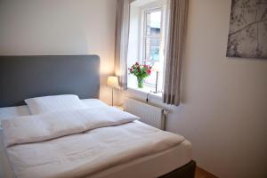 ein weißes Bett in einem Schlafzimmer mit einem Fenster in der Unterkunft Ferienwohnung Ella in Scharbeutz