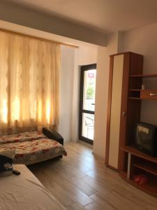 a bedroom with a bed and a window and a tv at Apartament Daniela in Năvodari