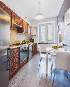 una cocina con armarios de madera y una mesa blanca con una mesa blanca. en Mokotow Accommodation P&O Serviced Apartments, en Varsovia