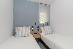 two beds with white pillows in a bedroom at Apartments Flora Trogir in Trogir