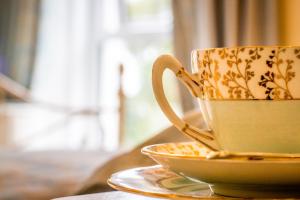 a coffee cup sitting on a plate on a table at Altahammond House in Carrickfergus