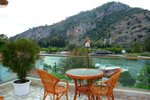 a table and chairs with a view of a river at Cinar Sahil Pansiyon in Dalyan