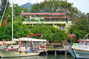 two boats docked in the water in front of a building at Cinar Sahil Pansiyon in Dalyan